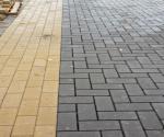 waterpasserende bestrating (grijs) naast traditionele betonnen klinkers